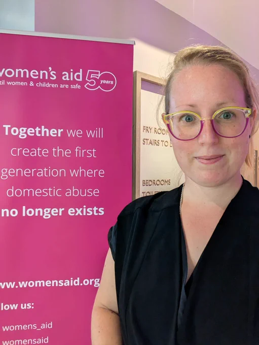 mySociety's Jen in front of a Woman;s Aid banner