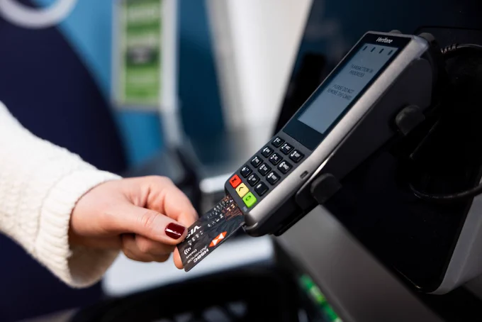 A shopper putting their credit card into a credit card machine.