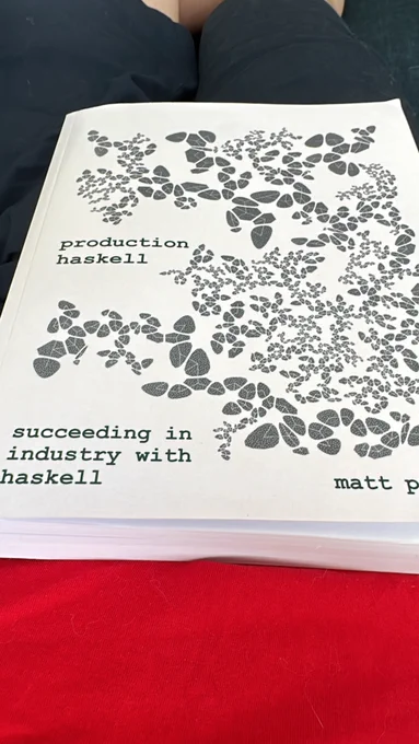 Me sitting in my soffa with production haskell book in my tommy, covered in fur because yes I have two cats I'm sorry