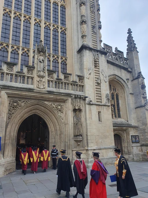 This photo shows the entrance to Bath abbey and a number of University staff and academics parading in through the door in their formal robes for the graduation reception.
