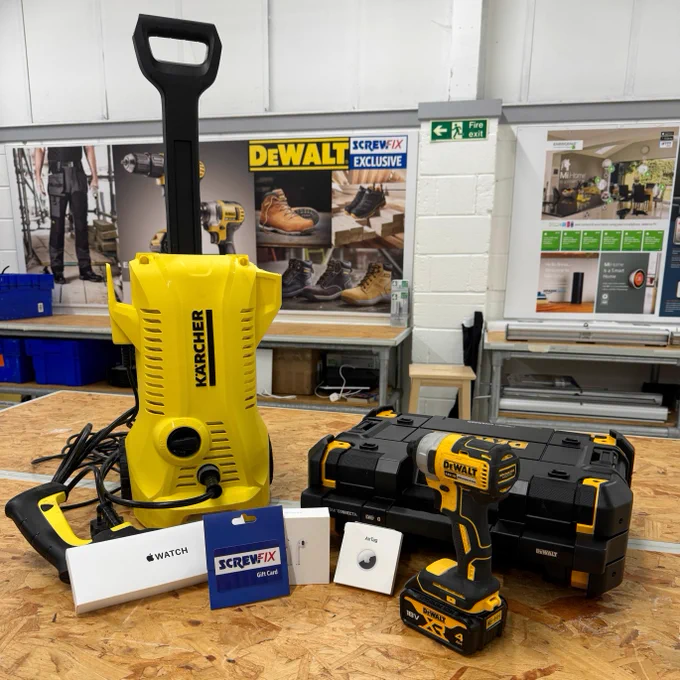 A Kärcher pressure washer, DeWalt power tool set, and various Screwfix items displayed on a workbench in a Screwfix store workshop.
