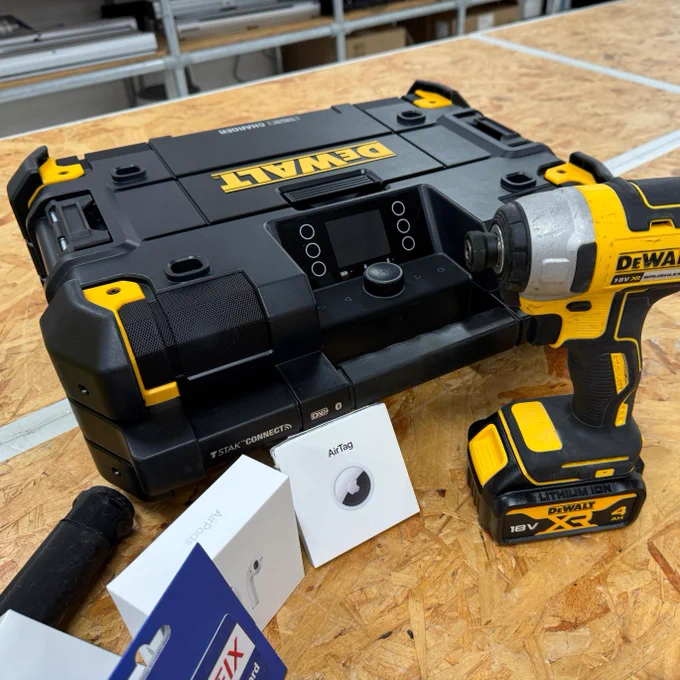 This image features a DeWalt tool kit box and a yellow DeWalt power drill resting on a workbench. Alongside the drill, there are various items like a hammer, a badge with "Arturo" written on it, and several cards spread around. The tool kit box is labeled with "DEWALT" prominently at the top.