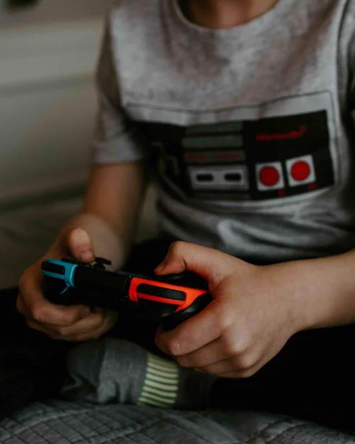 A video game controller in the hands of a child