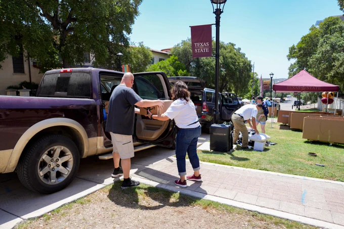 Family and staff helping during TXST move in unload cars
