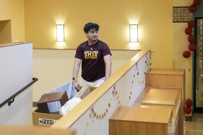TXST student pulling in a cart during move-in