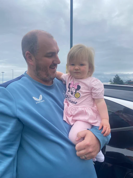 Adult male holding his baby daughter in his arm