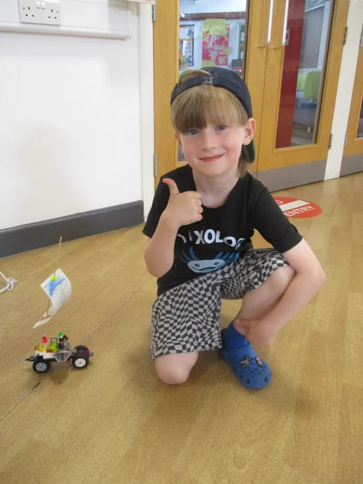 boy with thumbs up next to wind powered lego car