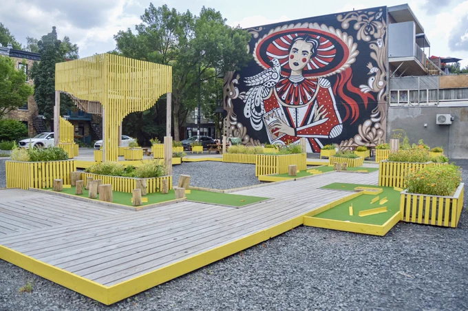 A temporary mini-golf course surrounded by benches, planters, and street art on a disused industrial site in Montreal.