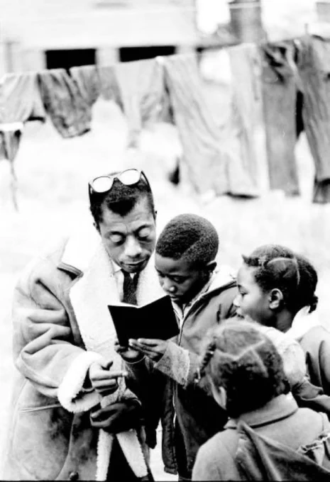 Photo of James Baldwin reading with children.