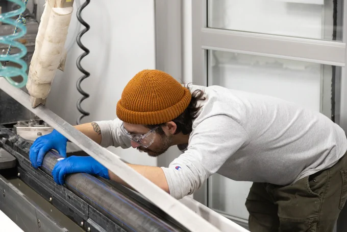 River Rivera (Marine Laboratory Specialist, IODP JRSO) lines up core sections for splitting. (Credit: Daniel Rudbäck, IODP JRSO) 
