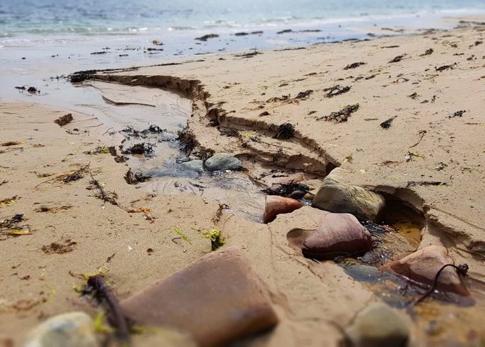 Water running down a beach to the sea