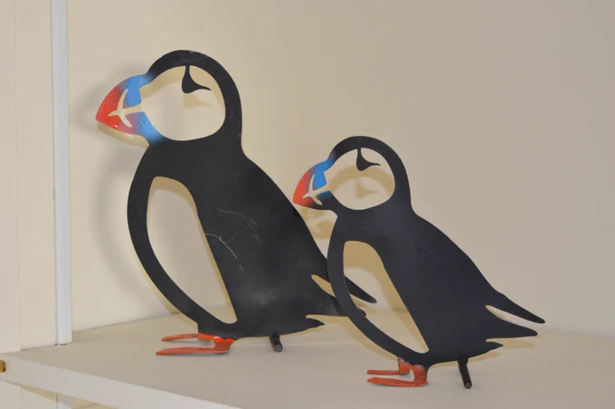 Two metal sculptures of puffins