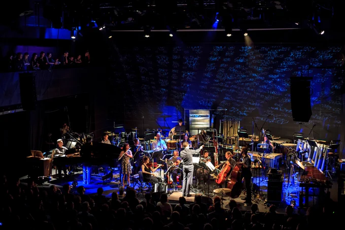 A large musical ensemble performs on stage.