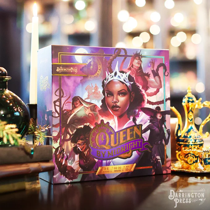 Photography of the deck-building boardgame Queen by Midnight, propped up on a table with ornate finery nearby