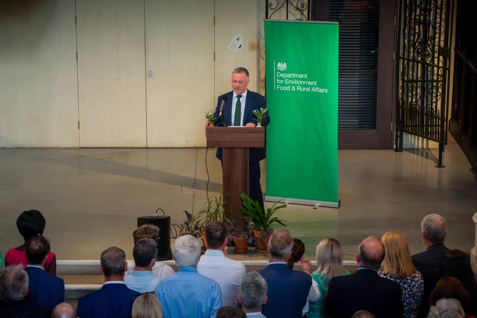 Secretary of State on stage doing a speech to a group of stakeholders