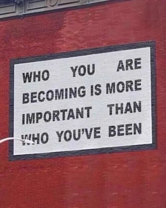 A mural painted on a brick wall that reads "Who you are becoming is more important than who you've been."