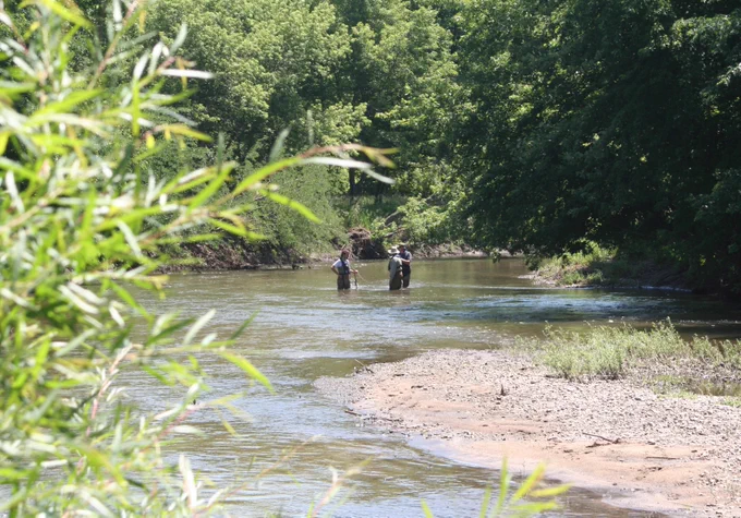 Scientists collect water samples from a stream in Iowa.
