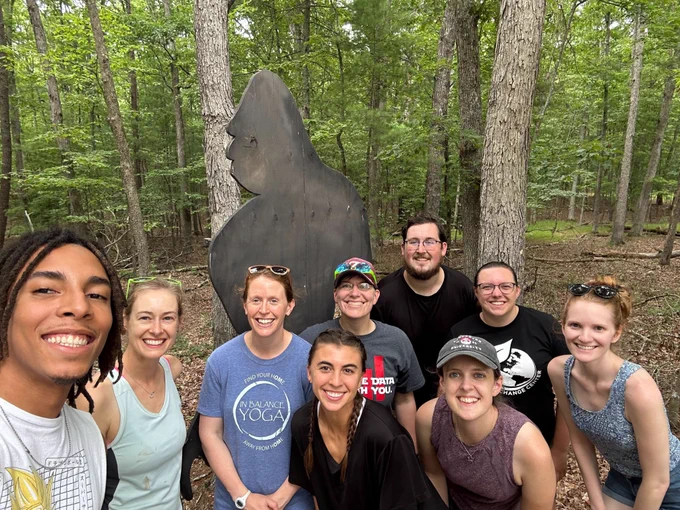 Carey Lab 2024 retreat photo of team on a hike at the Carvins Cove Reservoir watershed (with Sasquatch in the background)