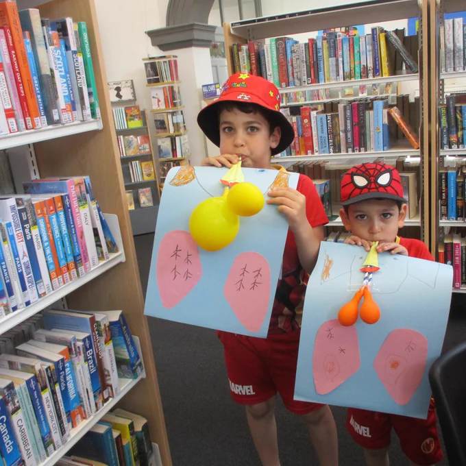 two boys inflating balloons