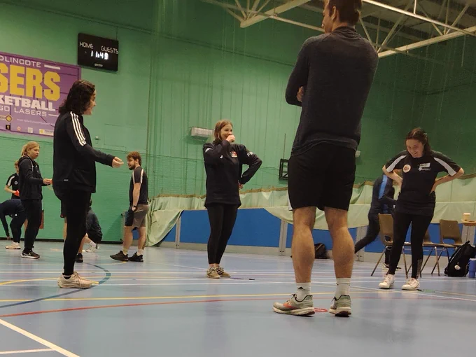 Group of individuals gathered at a basketball court for an Activity Alliance session.