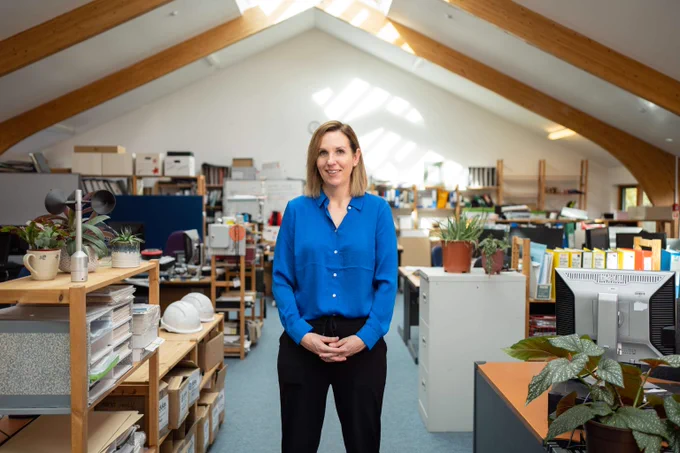 Dulas' managing director, Ruth Chapman in an office with several filing cabinets, plants and computers.