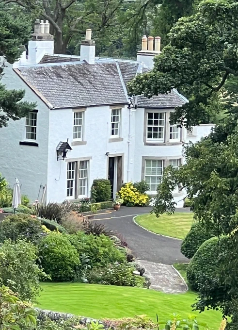 A white cottage set in beautiful gardens