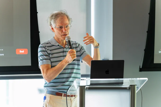 Man speaking into a mic at a podium