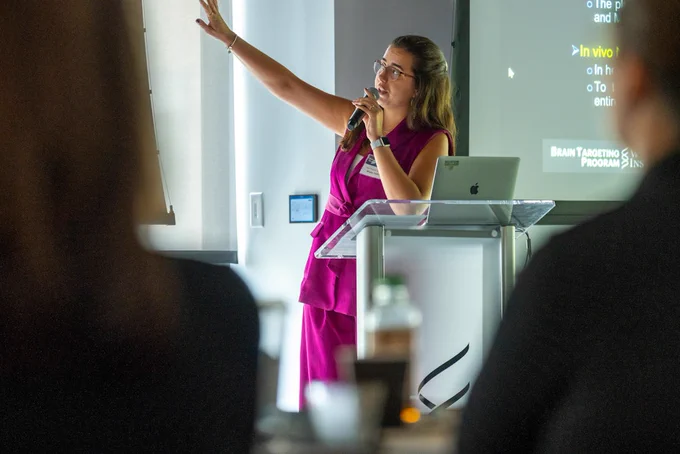 A woman presenting, gesturing behind her