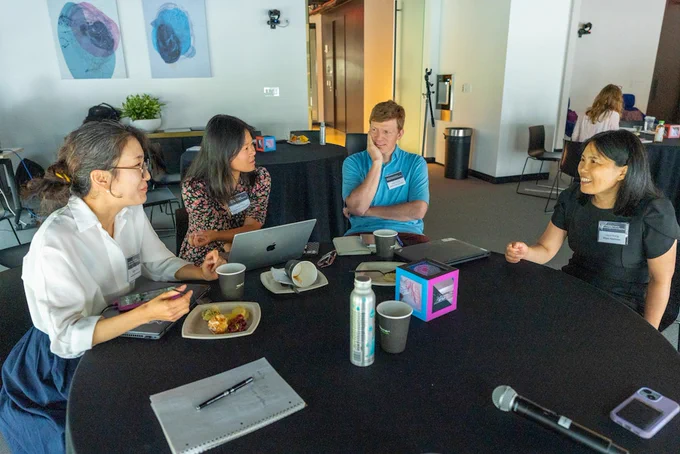 Four people at a table having a discussion