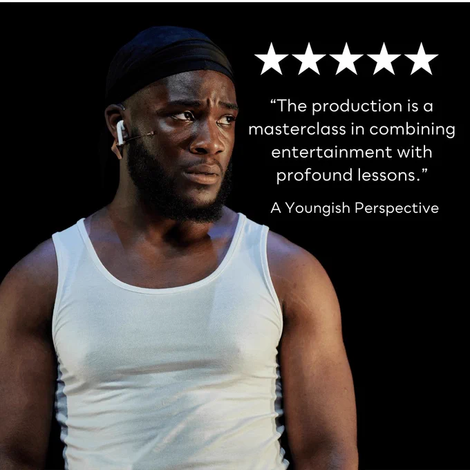 A black man performing on stage with a pensive look on his face as he looks in to the distance