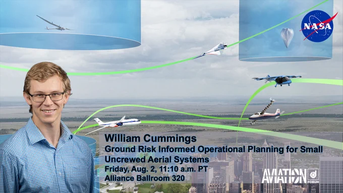 A smiling man wearing glasses and a blue checked oxford shirt stands in front of an artist's conception of an urban landscape with different kinds of aircraft flying overhead.