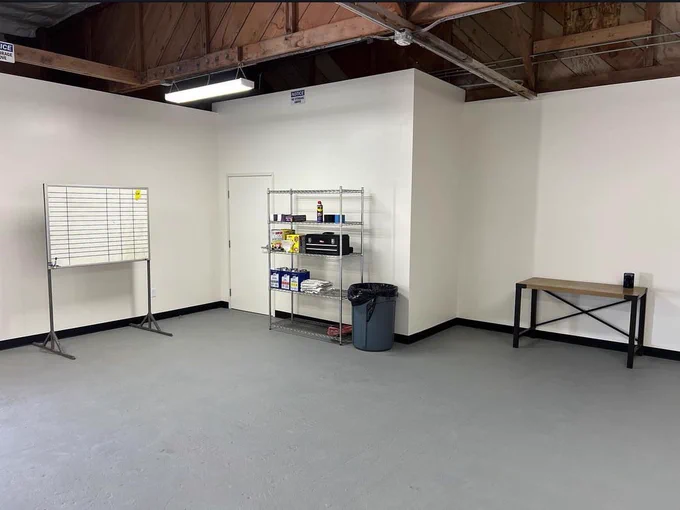 Clean workroom with table, shelves and white board for innovation development.