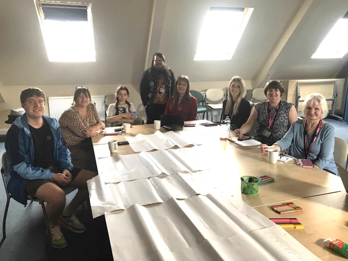 Group of co-researchers gathered around a meeting table