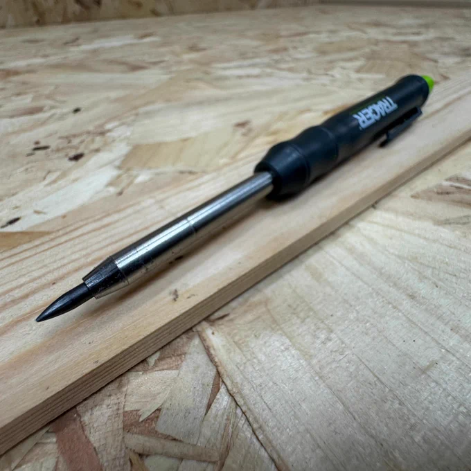 A Tracer pencil placed diagonally on a plywood surface.