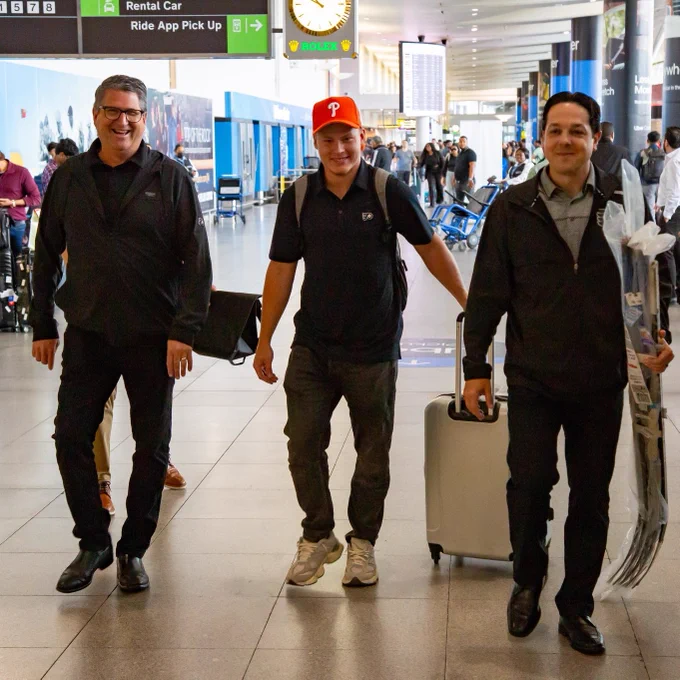 From left to right: Keith Jones, Matvei Michkov, and Daniel Briere in an airport.