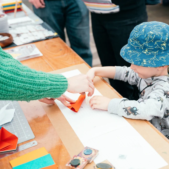 A maker is creating something with a child at Assemble 2022. 