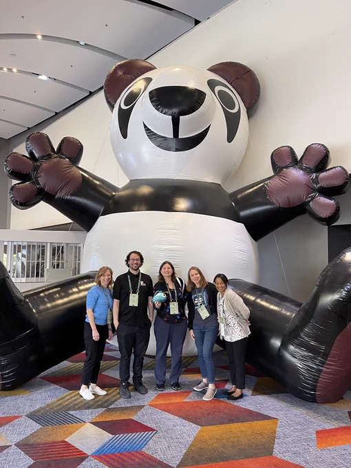 Team EIT posing in front of a large blow-up panda. 