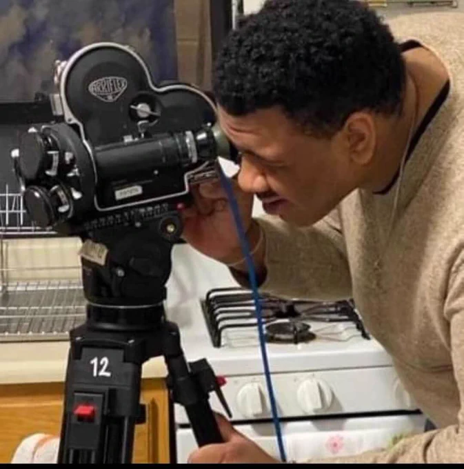 A man stands and looks into a video camera. 