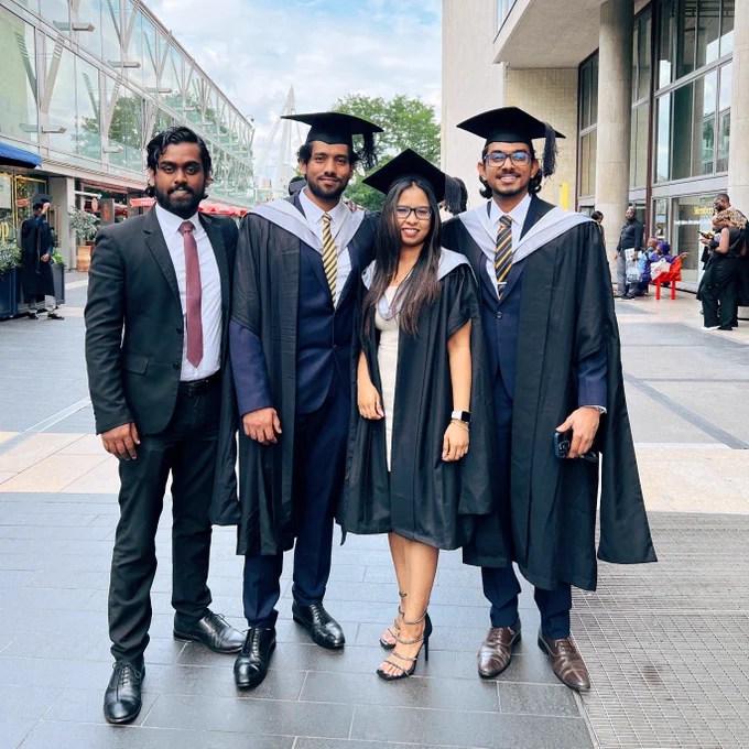 Four graduates in cap and gowns