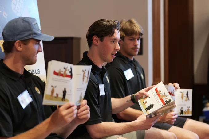 Mathieu Caron (middle) reads Up the Creek alongside Ryan Bischel (left) and Owen Pederson (right)