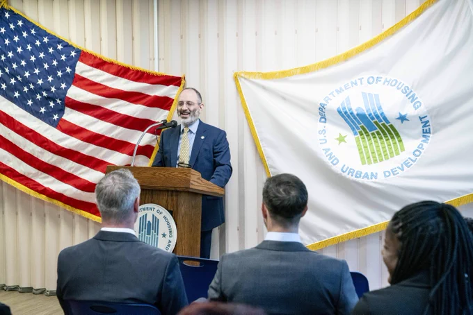 Deputy Assistant Secretary Handelman speaking at a podium as people sit in the crowd and watch.