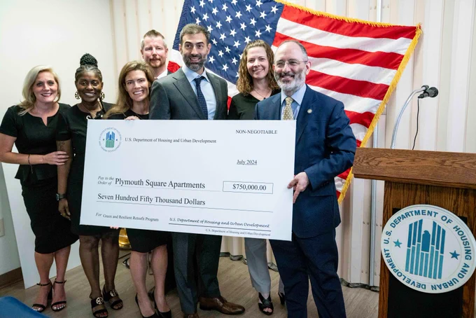 A group of people posing for a photo with a big check.