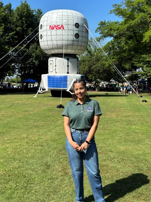 Monica Perez poses for a photo at the NASA in the Park Event in downtown Huntsville. In the background is an inflatable space habitat.