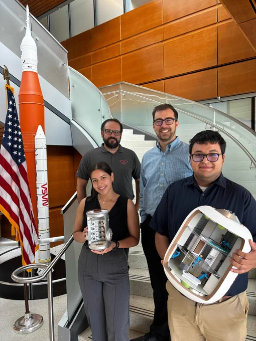 Monica Perez poses for a photo with her mentors, Daniel Perri and Andrew Choate, and another Marshall intern, Edgar Villanueva while holding a space habitation model.