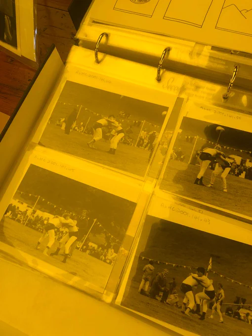 Black and white photos of Cumbrian wrestlers are displayed in a ring binder on the table at the museum's stall