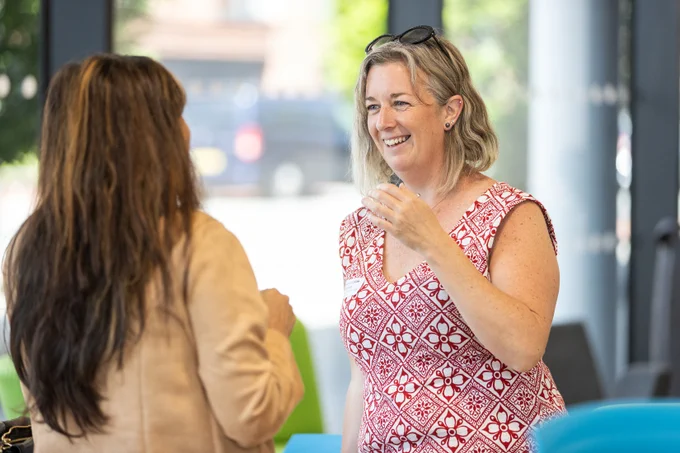 Two women having a chat and smiling after taking part in a training session