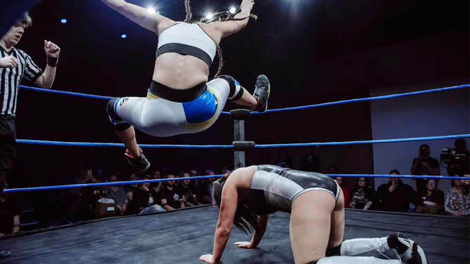 A wrestler leaps over (or onto) an opponent