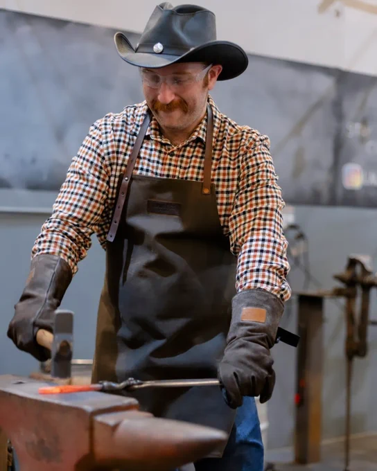 From another angle, Joe hammers the piece of red hot molten iron