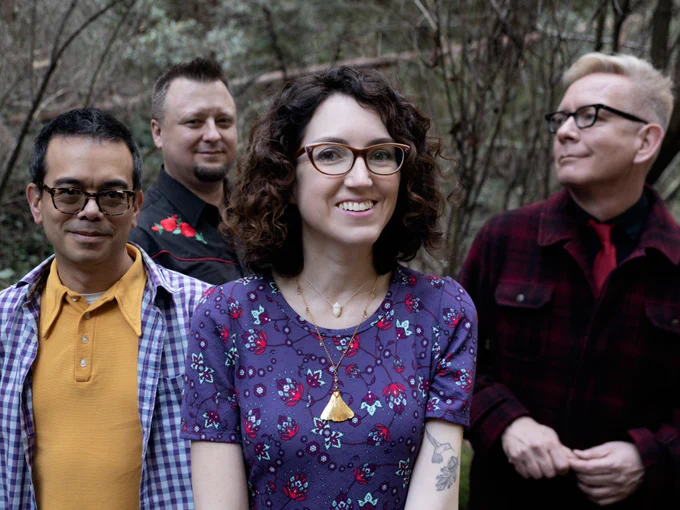 Four members of The Corner Laughers stood in a woodland setting