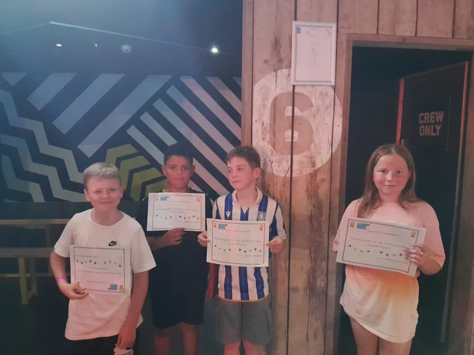 Four young people stood holding certificates.